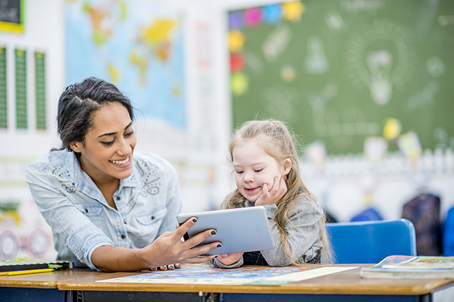 Special Educator in class engaging with student. Special Educator in class engaging with student.