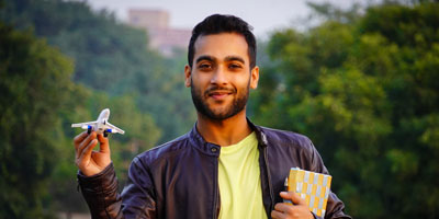 Study Abroad Scholarships College student holding a small airplane