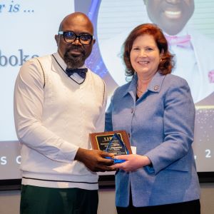 Godwin Agboka and Provost Bordelon posing for a photo on stage.