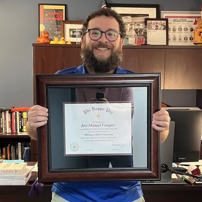 Jose Vazquez holding his Phi Kappa Phi certificate.