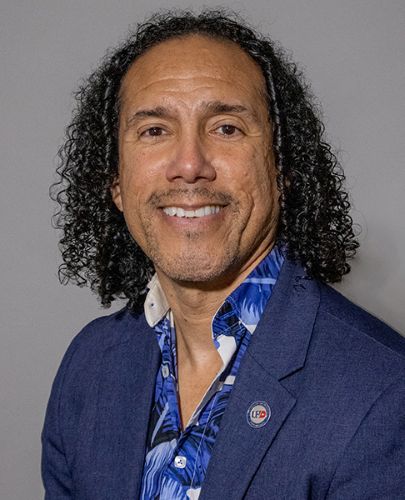 Dean José Ricardo-Osorio in a flower-print shirt and blue jacket.