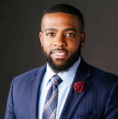 Brandon Lee professional headshot. He is wearing a blue suit with a light blue shirt and striped tie.