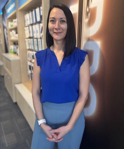 Natasha Maniaci poses for a professional photo. She is wearing a blue shirt and light blue pants.