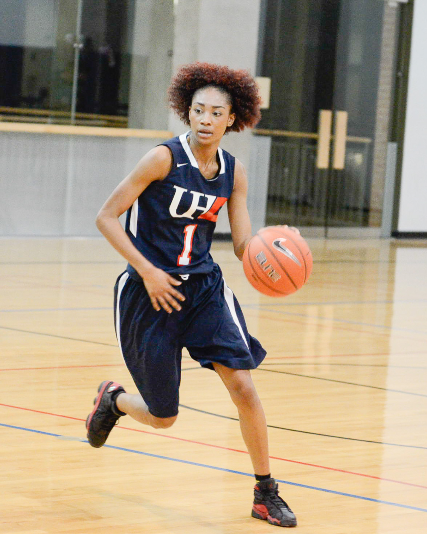Female student dribbling a  basketball 