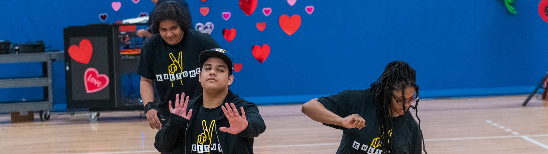 three students dancing in the gym
