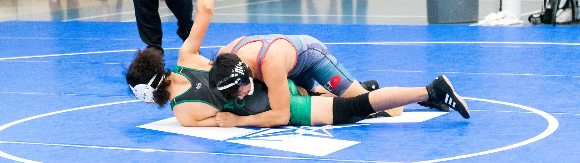 male UHD wrestler pins down his opponet to the mat
