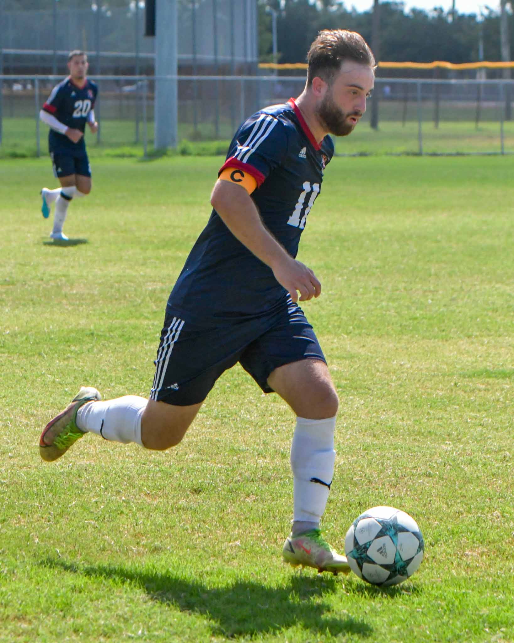 Male student running with a soccer ball 