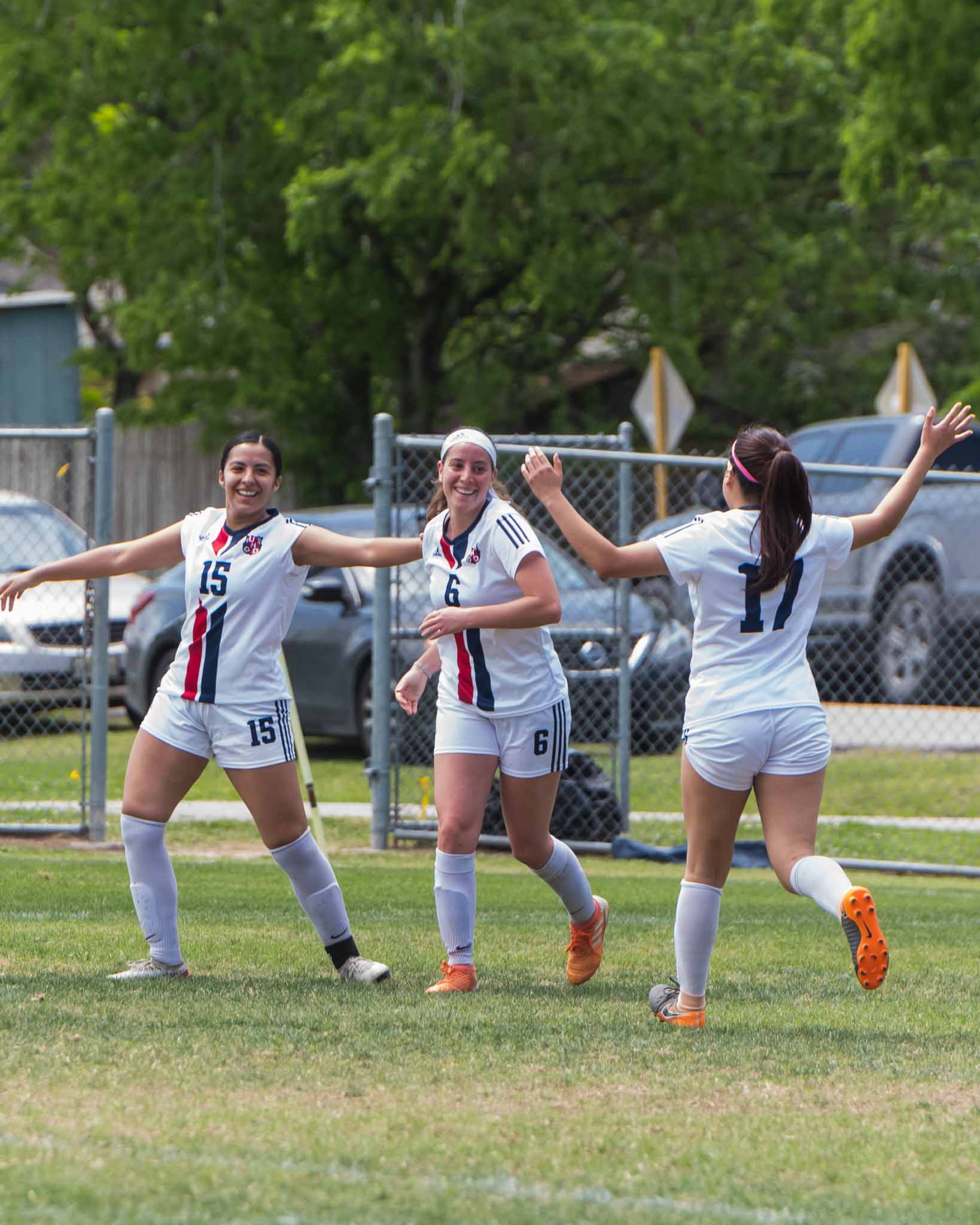 Female soccer players with their hands up in the air 