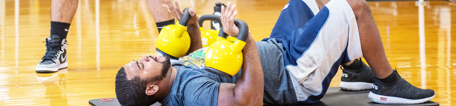 man does sit up with small kettle bell weights