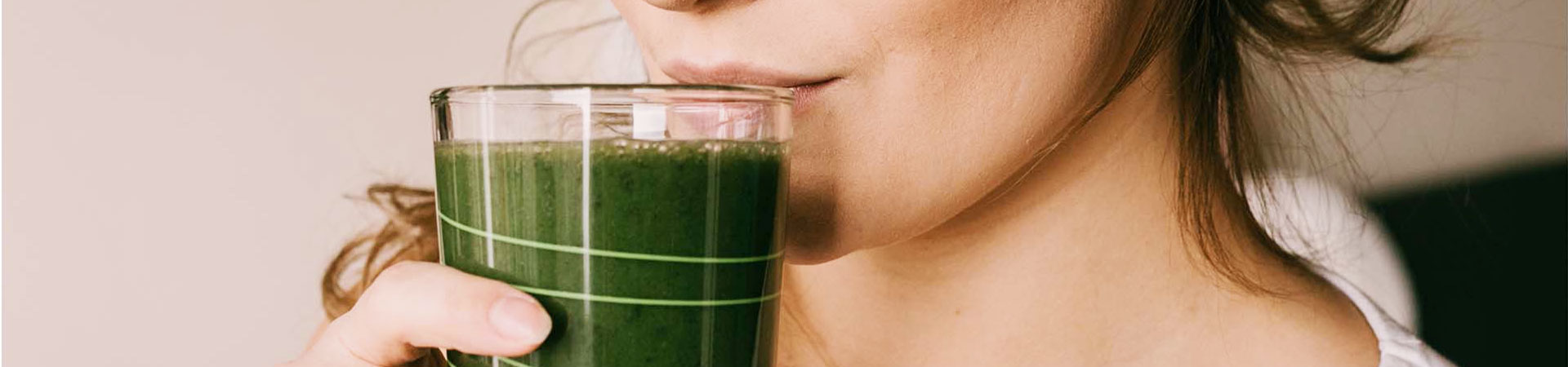 person drinking a green healthy beverage
