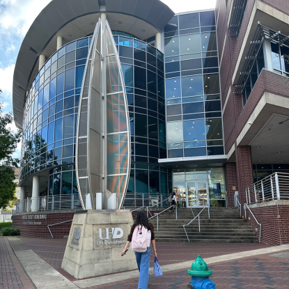 A student walking up to University of Houston-Downtown's College of Public Service in Downtown Houston