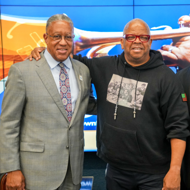 The University of Houston-Downtown President Dr. Loren Blanchard stands aside Terence Blanchard at a 2024 President's Lecture Series.