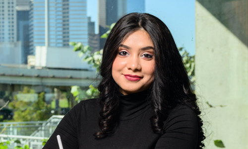 International student sitting at a table and smiling